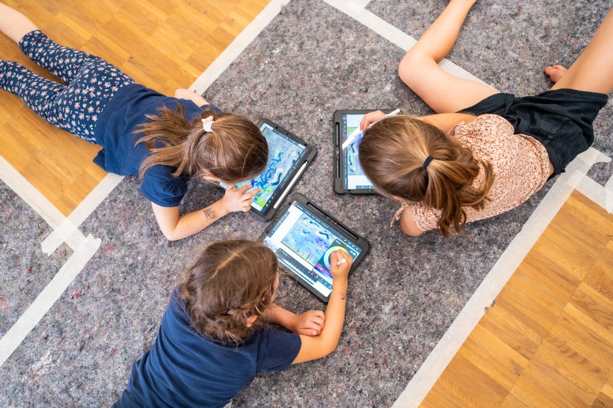 Die Teilnehmenden der Klassen 1 bis 4 kombinieren analoge und digitale Techniken – auf Papier entstandene Werke werden eingescannt, am Tablet verändert, ausgedruckt und wieder mit Pinsel und Stiften übermalt. Quelle: BVR / Fotograf: Marius Schwarz 