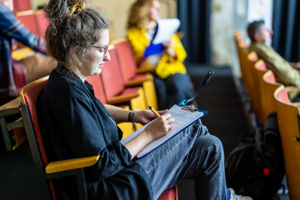 Für die Bewertung der Kurzfilme notieren die Jurymitglieder wichtige Details zu Inhalt, Gestaltung, Originalität und Eigenständigkeit. Quelle: BVR / Fotograf: Marius Schwarz

Im Bild: Bundesjurorin Lea Schütte (Kulturelle Bildnerin mit Schwerpunkt Filmbildung & Vermittlung)


